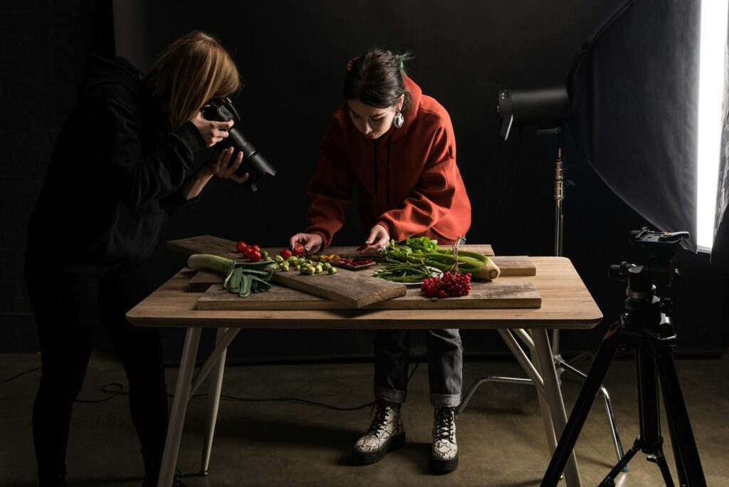 two photographers making food composition for commercial photography and taking photo on digital